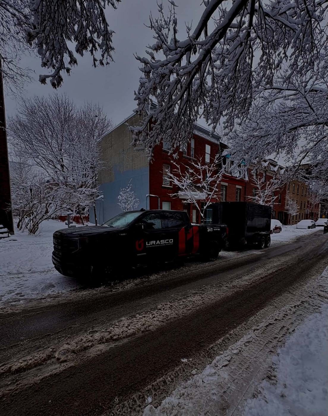 Camion et remorque Urasco dans une rue enneigée